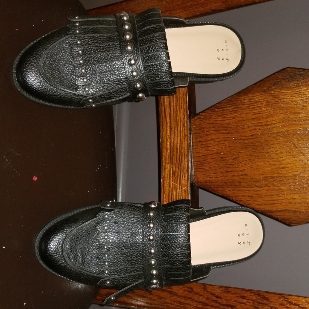 Black moccasins styled flats with anexposed heel.